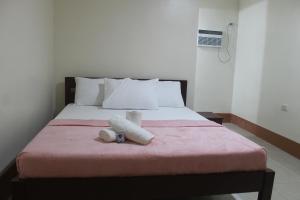 a bedroom with a bed with two towels on it at JUNLYN APARTELLE in Panglao Island