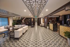 un vestíbulo de hotel con sofás blancos y una escalera en Venus Halong Cruises en Ha Long