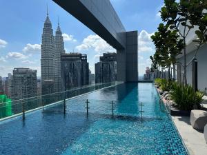 a swimming pool on the roof of a building with a city at Royce Residences by Romeo Bnb in Kuala Lumpur