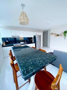 a kitchen with a green table and chairs at Crucita con Guardianía y acceso a Playa Privada y Piscina in Crucita