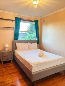 1 dormitorio con 1 cama grande y ventana en 5 BR & 3 BTH House in Outlook Glen w/ 2 car parks, en Glen Waverley