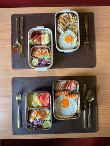 duas bandejas de comida para o pequeno-almoço numa mesa em The Terminal Khon Kaen Hotel em Khon Kaen