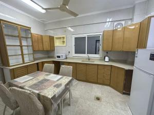 a kitchen with a table and a white refrigerator at شقة مطلة على قباء in Medina