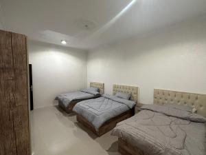 a bedroom with three beds in a room at شقة مطلة على قباء in Medina