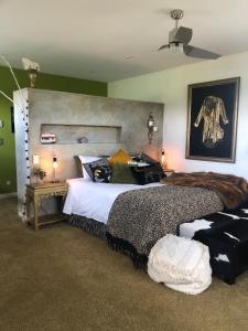 a bedroom with a large bed with a large headboard at The Artist's House Wanaka in Luggate
