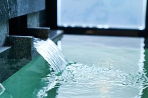 a water fountain in a pool of water at Hakone Kowakien Hotel in Hakone