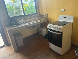 a kitchen with a stove and a sink at Casa Sendero in Liberia