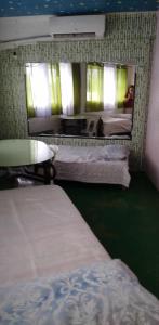 Habitación con 2 camas y un perro en un espejo. en Quickshape/Quickshield Homestay en Naga