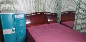 - une petite chambre avec 2 lits et une commode dans l'établissement Quickshape/Quickshield Homestay, à Naga