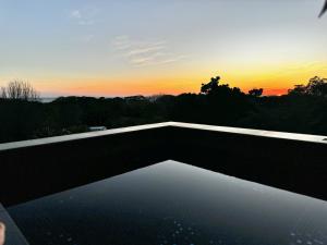 a view of the sunset from a swimming pool at KUNUK- Walk to Hermosa beach in Santa Teresa Beach