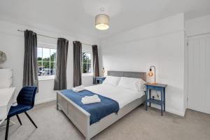 a bedroom with a bed and a chair and a window at End of Terrace 3 bedroom House with Garden in Newmarket