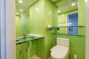 La salle de bains verte est pourvue de toilettes et d'un lavabo. dans l'établissement Little Prince Hotel, à Gunsan