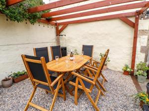 a wooden table and chairs on a patio at The Back House in Staindrop