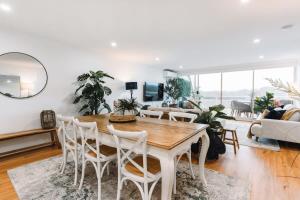 sala de estar con mesa y sillas en Lakeside 3-Bed Apartment with Jacuzzi, en Belconnen