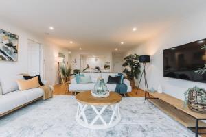 sala de estar con sofá blanco y mesa en Lakeside 3-Bed Apartment with Jacuzzi en Belconnen