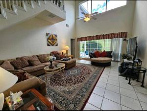 a living room with a couch and a ceiling fan at Elysian deluxe villa in Davenport