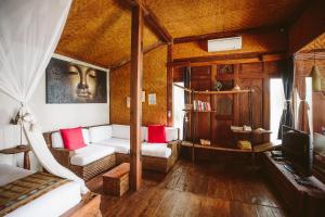 Una sala de estar con una cama y un televisor. en Sejuk Beach Villas, en Canggu