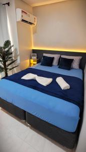 uma grande cama azul com duas toalhas brancas em Loft 3 Novo 5 min aeroporto Marabá em Marabá