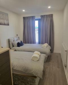 a room with three beds with towels on them at 2 Bedrooms 2Baths 3Toilets near Excel City Airport O2 Sleeps up to 5 in London