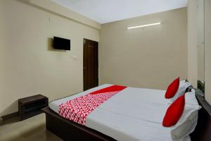 a bedroom with a bed with red pillows on it at A S Hotels Ranchi in Rānchī