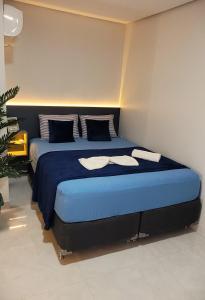 um quarto com uma cama grande e lençóis azuis em Loft 3 Novo 5 min aeroporto Marabá em Marabá