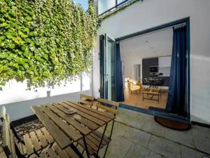 a patio with a wooden bench and a dining room at Pass the Keys Modern and Bright Home Minutes From Central London in London