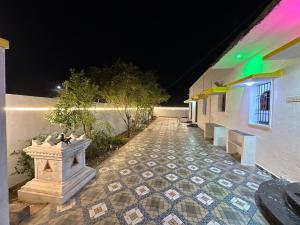 a tiled walkway in front of a building at night at Arunachala Sashwin Guest House in Tiruvannāmalai