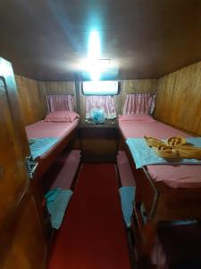 een kleine kamer met 2 bedden en een kom bananen bij Open Trip Komodo 3D2N in Labuan Bajo