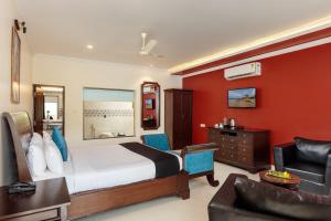 um quarto de hotel com uma cama e um sofá em WILD BERRY RESORT AGONDA em Canacona