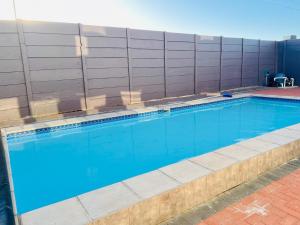 a swimming pool with blue water in front of a building at Pemba's residence in Cape Town