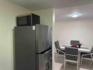 eine Küche mit einem Kühlschrank und einem Tisch mit Stühlen in der Unterkunft Apartamento cerca autódromo in Mexiko-Stadt