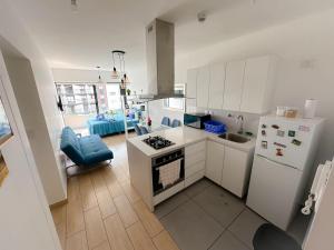 a kitchen with white cabinets and a stove top oven at Apartamento exclusivo a 70 metros de san Isidro in Lima