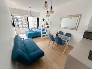 uma sala de estar com um sofá azul e uma mesa em Apartamento exclusivo a 70 metros de san Isidro em Lima
