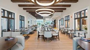 Un restaurante con mesas, sillas y ventanas. en Amazing Villas 20 minutes away from Disney!, en Kissimmee