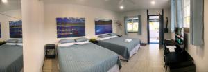 1 dormitorio con 2 camas y pinturas en la pared en Island Hopper, en Yepan