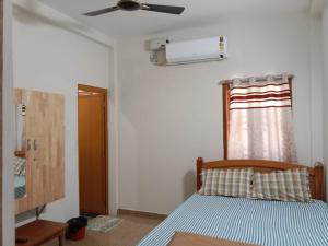 1 dormitorio con 1 cama y ventilador de techo en Prajay Inn - Yelagiri, en Yelagiri