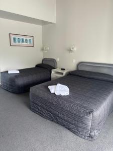 a hotel room with two beds with towels on them at Helensborough Motor Inn in Balclutha