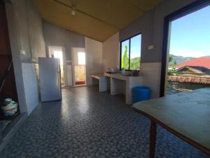 a kitchen with a refrigerator in the middle of a room at House no 39 in Kota Belud