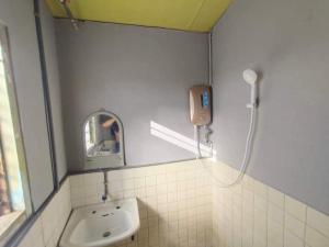 ein Bad mit einem Waschbecken und einem Spiegel in der Unterkunft House no 39 in Kota Belud