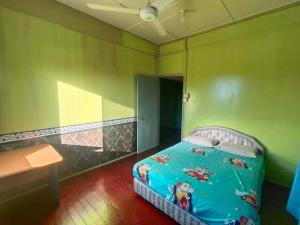 1 dormitorio con 1 cama en una pared verde en House no 39 en Kota Belud