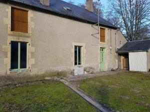 una vecchia casa con una porta verde e un cortile di Gîte cosy et indépendant avec terrasse, jardin clos, internet 4G, tout compris - Bengy-sur-Craon - FR-1-586-34 a Bengy-sur-Craon