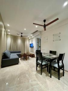 a living room with a table and chairs and a couch at 1 BHK in Hiranandani Powai. in Mumbai