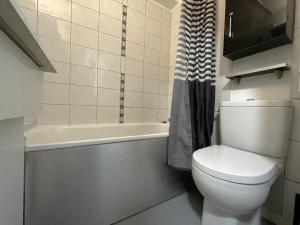 a small bathroom with a toilet and a bath tub at Studio Les Menuires, 1 pièce, 3 personnes - FR-1-452-386 in Les Menuires