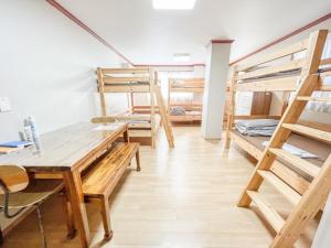 a room with several bunk beds and a table at Empathy Guesthouse in Daegu