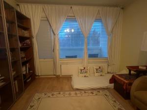 een woonkamer met een groot raam met witte gordijnen bij Whole Apartment in Vantaa