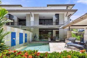 a house with a swimming pool in front of it at Villa Sanctuary in Temple - Resort Living Redefined in Port Douglas