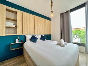 a bedroom with a large bed with a blue wall at Sea and mountain views from your Rooftop ! in Saint-Laurent-du-Var