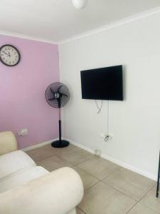 a living room with a fan and a tv at 24 on Elizabeth in East London