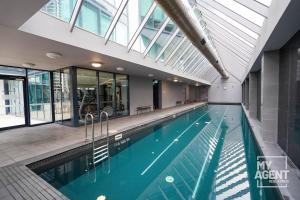 墨爾本的住宿－Luxury Living at Its Finest，一座带玻璃天花板的建筑中的游泳池