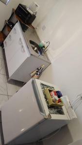 a kitchen with a white refrigerator with a magazine on it at Don Will Aparts in Puerto Esperanza
